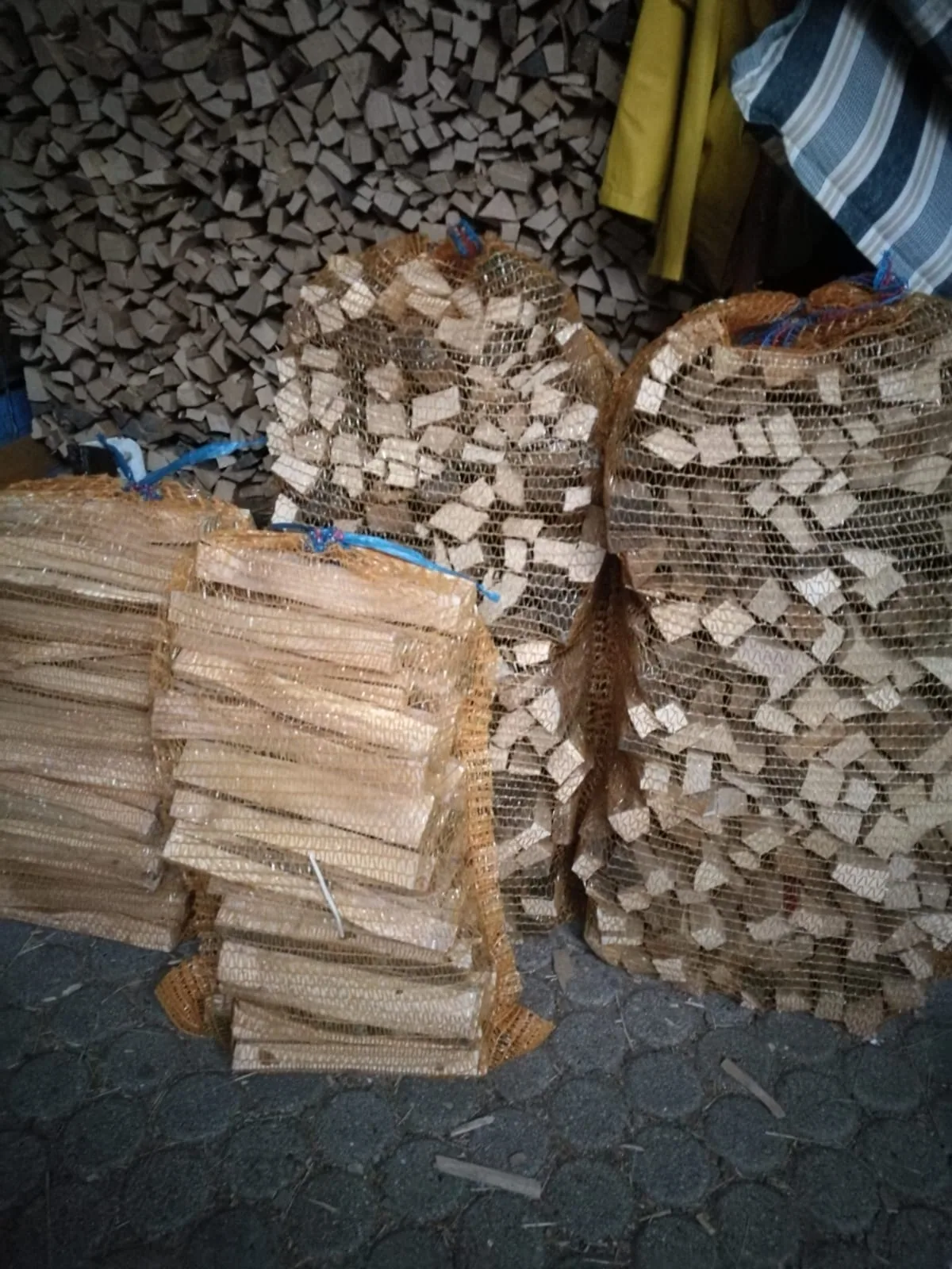 Gebündeltes Anzündholz vor einem Scheitholzstapel